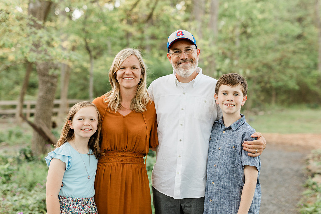 A family stands together smiling in a park in Marietta, Georgia.