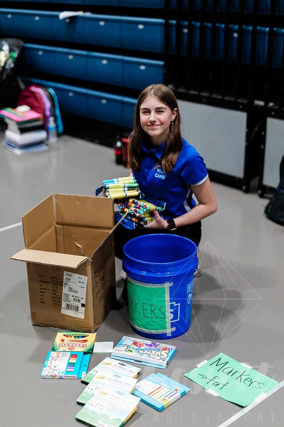 Girl sorts school supplies to be donated. 