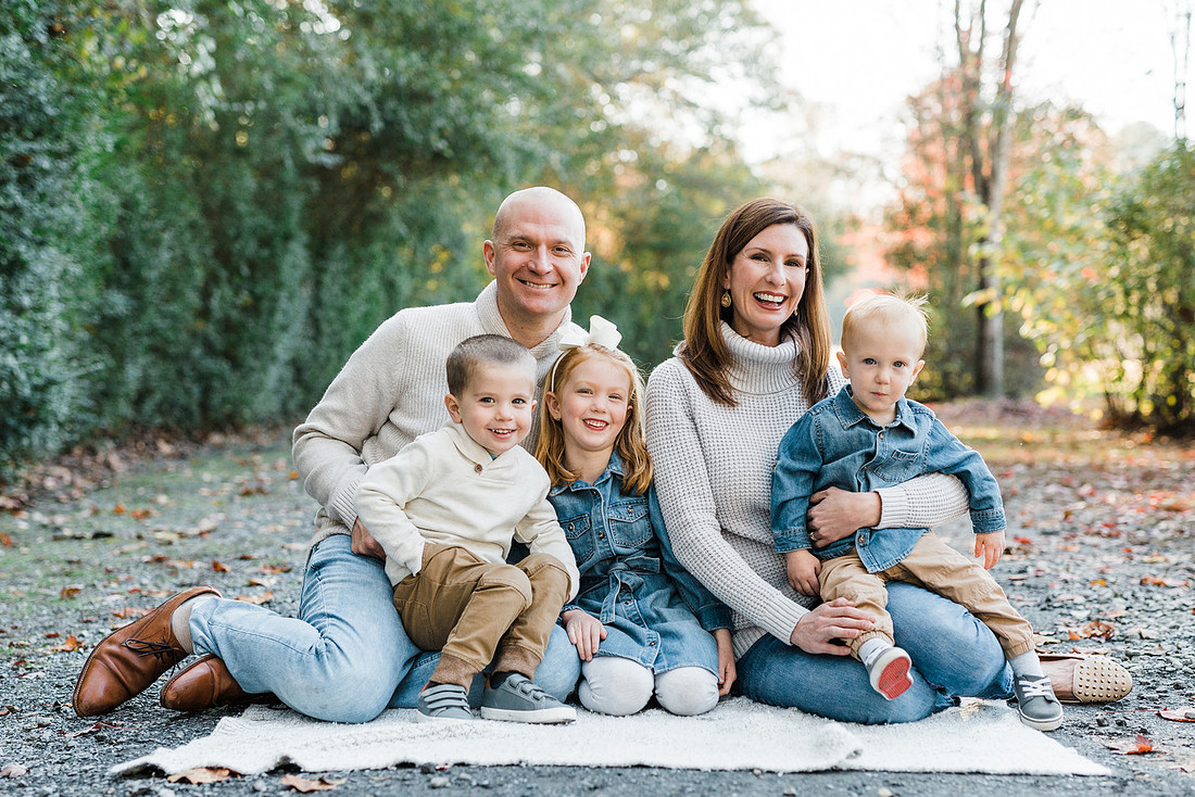 Family poses and enjoys candid moments during a mini session in a park