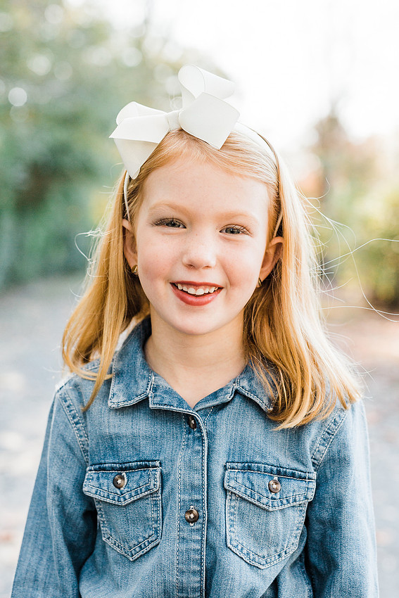 Family poses and enjoys candid moments during a mini session in a park