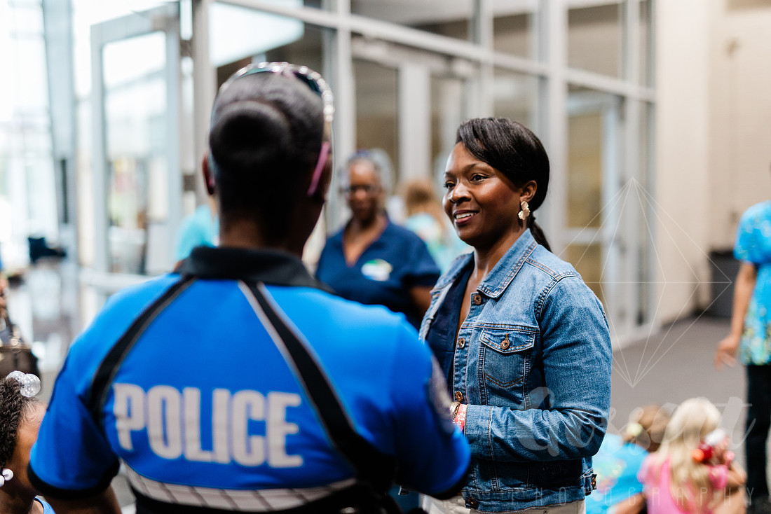 Lisa Cupid speaks to police officer at school supply drive in the Cobb County Civic Center.