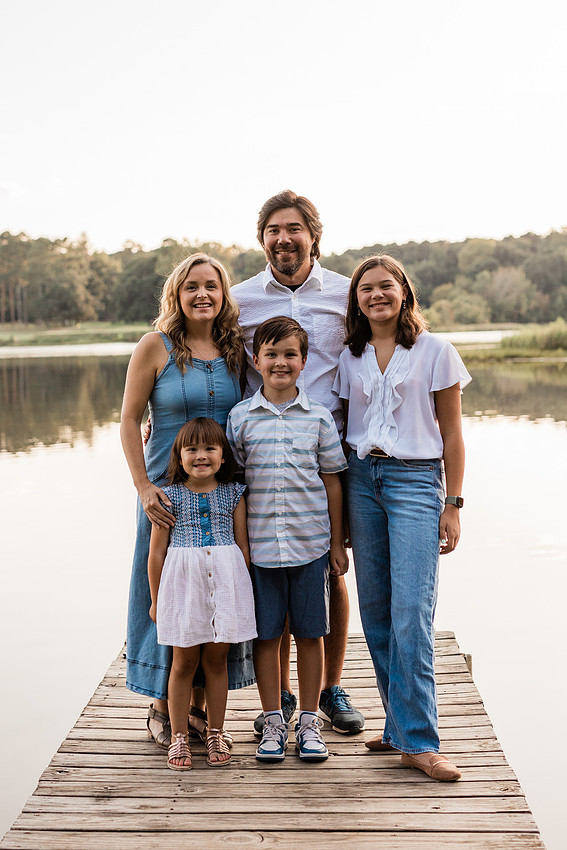 Family smiling on Cauble Park dock during spring mini session, outdoor family photography in Atlanta area.