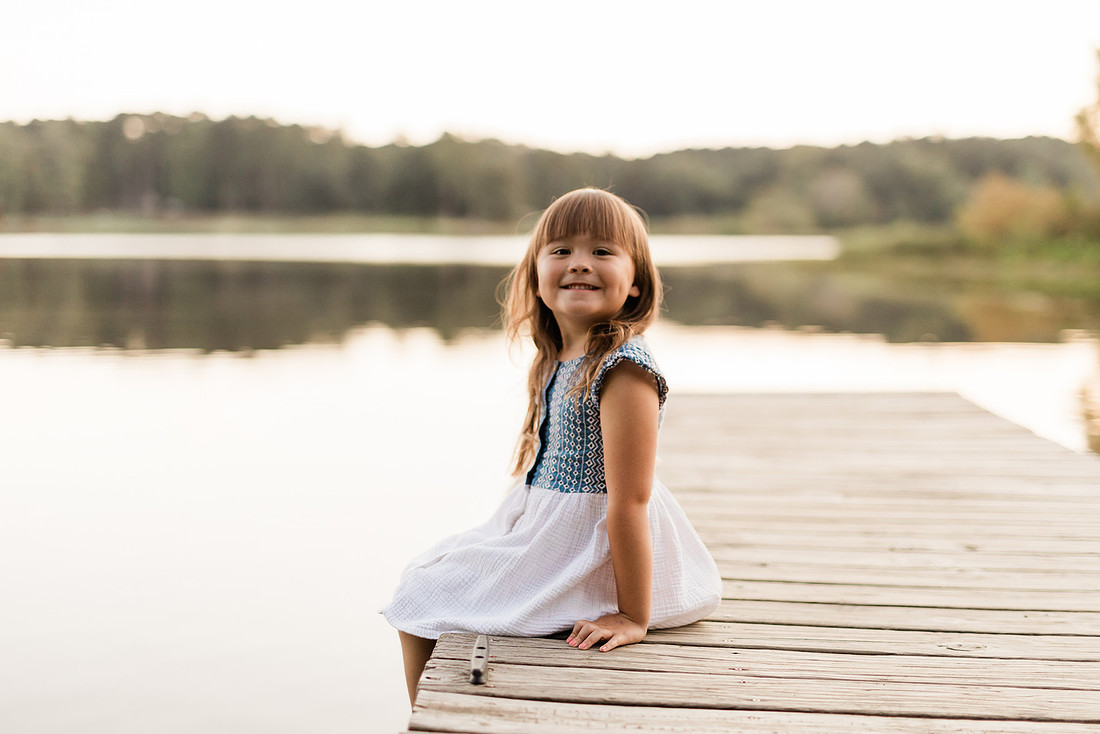 Family smiling on Cauble Park dock during spring mini session, outdoor family photography in Atlanta area.