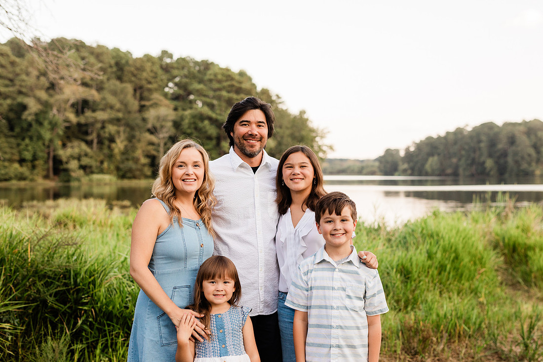 Family smiling on Cauble Park dock during spring mini session, outdoor family photography in Atlanta area.