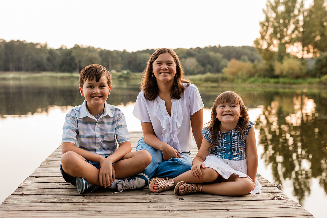 Family smiling on Cauble Park dock during spring mini session, outdoor family photography in Atlanta area.