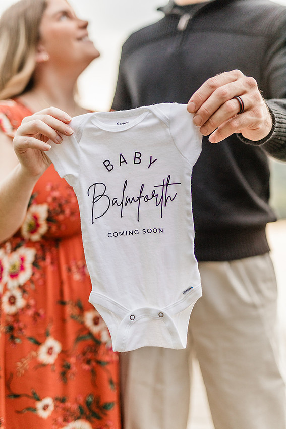 Outdoor maternity photography session with expecting parents captured in soft natural light