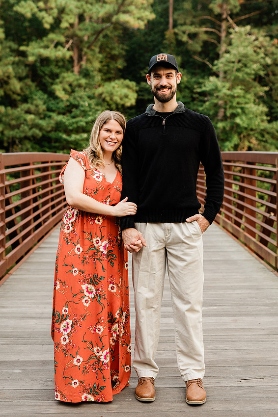 Outdoor maternity photography session with expecting parents captured in soft natural light