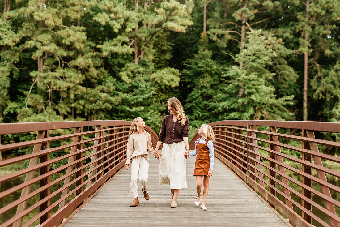 Family posing on a dock surrounded by calm lake water and soft evening light.