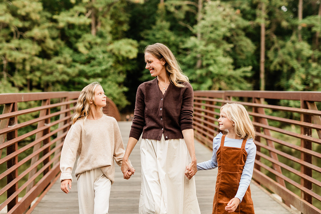 Family posing on a dock surrounded by calm lake water and soft evening light.