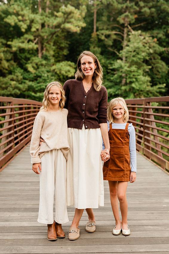 Family posing on a dock surrounded by calm lake water and soft evening light.