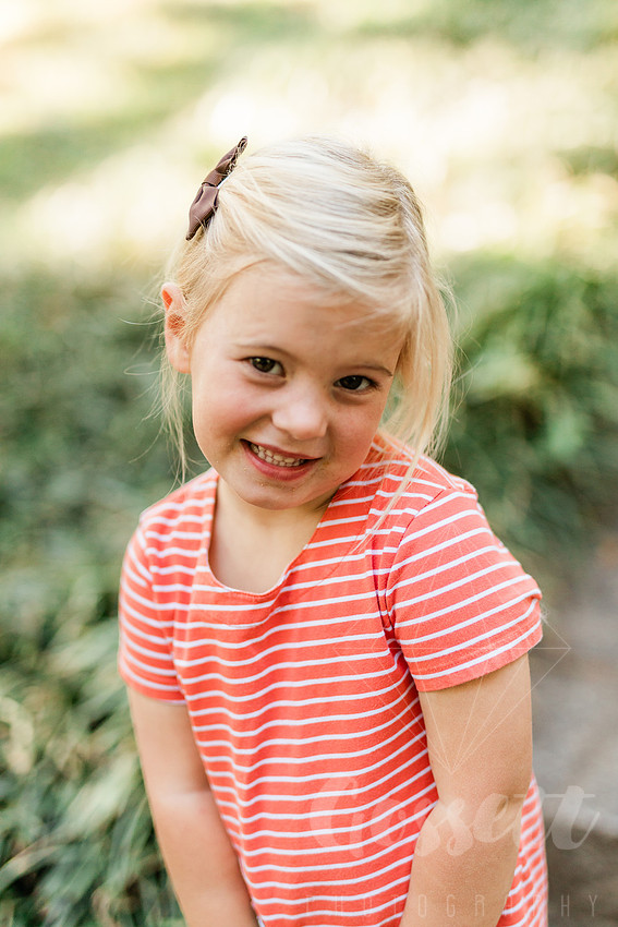 Family exploring a forest trail during a mini session, capturing playful, candid moments.