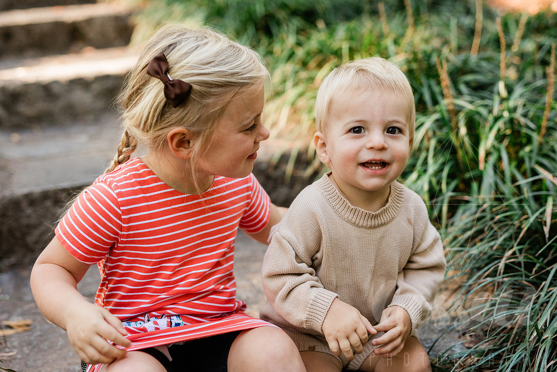 Family exploring a forest trail during a mini session, capturing playful, candid moments.