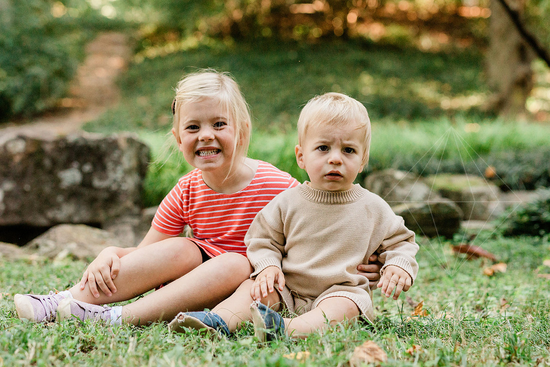 Family exploring a forest trail during a mini session, capturing playful, candid moments.