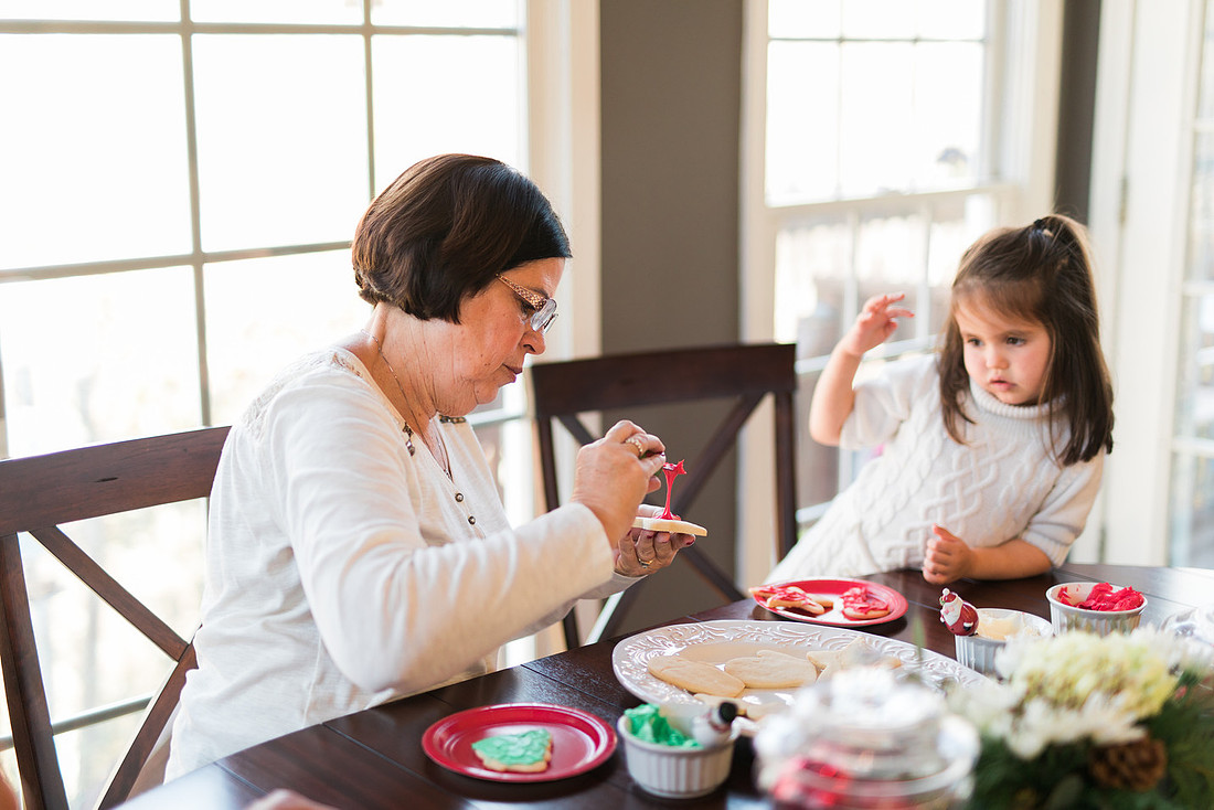 family bakes holiday cookies in their home while photographer captures candid moments