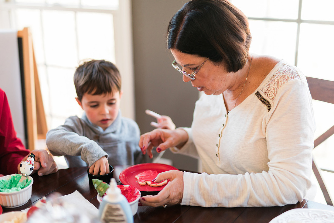 family bakes holiday cookies in their home while photographer captures candid moments