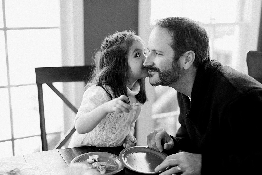 family bakes holiday cookies in their home while photographer captures candid moments