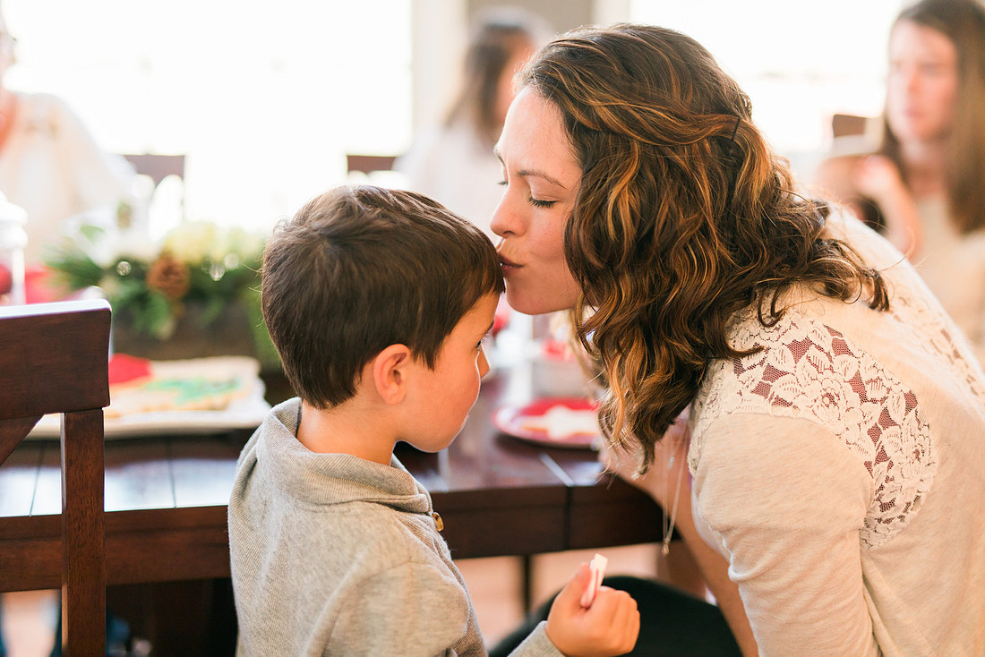 family bakes holiday cookies in their home while photographer captures candid moments