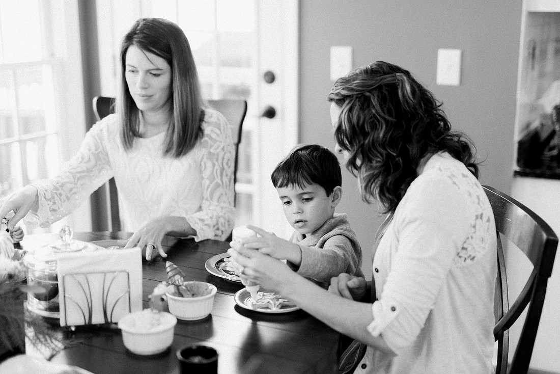family bakes holiday cookies in their home while photographer captures candid moments