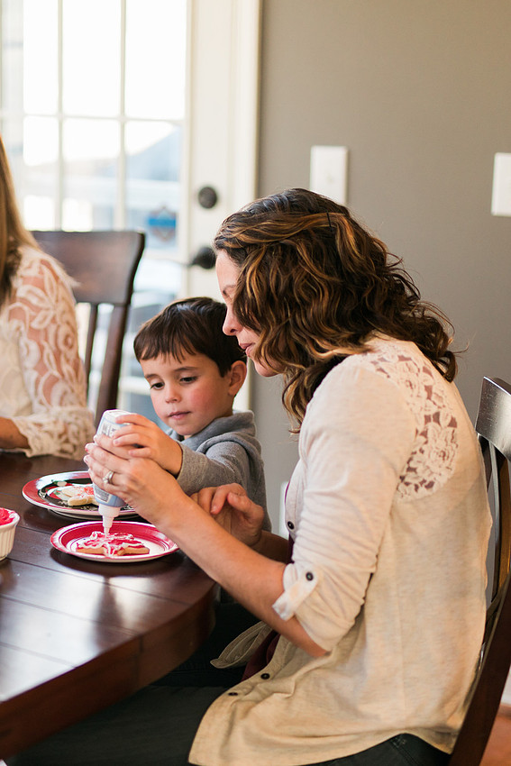 family bakes holiday cookies in their home while photographer captures candid moments