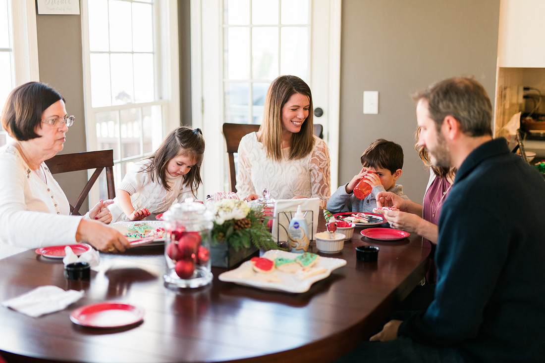 family bakes holiday cookies in their home while photographer captures candid moments