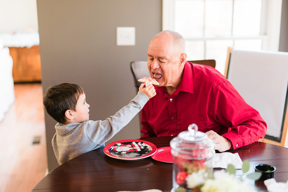 family bakes holiday cookies in their home while photographer captures candid moments