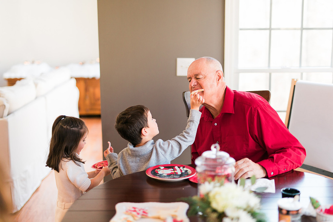 family bakes holiday cookies in their home while photographer captures candid moments