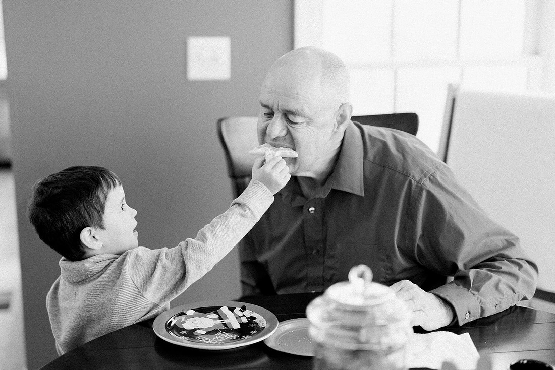 family bakes holiday cookies in their home while photographer captures candid moments