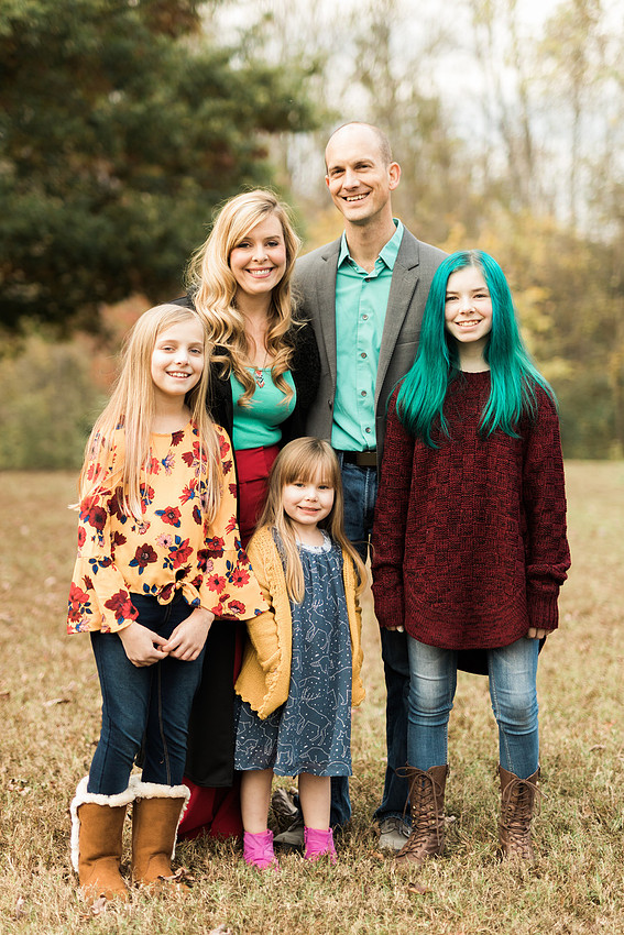 Family smiles for both posed and candid photos in a park