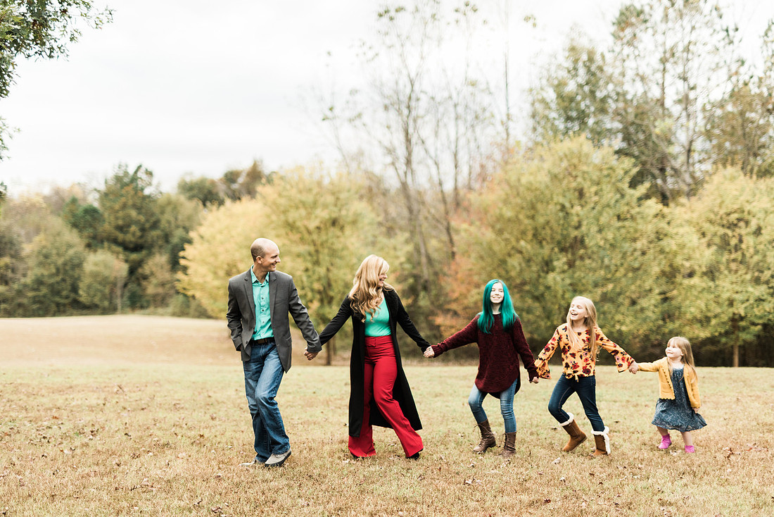 Family smiles for both posed and candid photos in a park