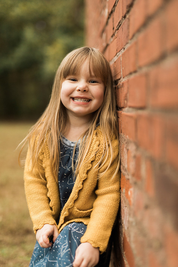 Family smiles for both posed and candid photos in a park