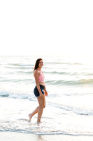 High School Senior Girl walks along coastline.