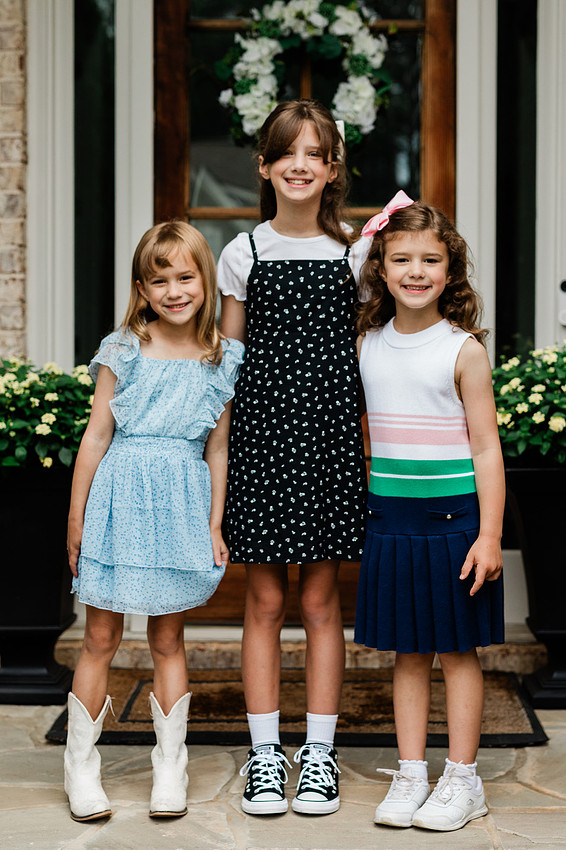 sisters together on their front porch, smiling for the first day of school.