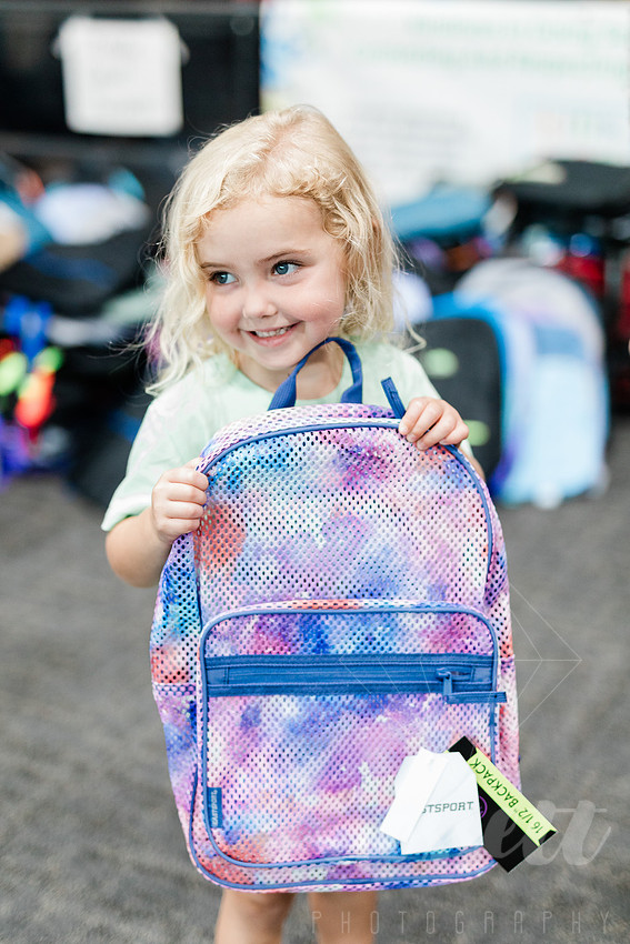 Young girl sorts backpacks to be donated