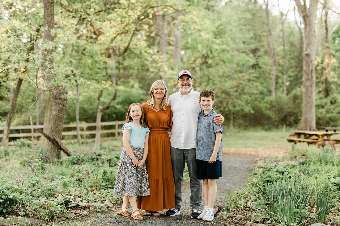 A family stands together smiling in a park in Marietta, Georgia.