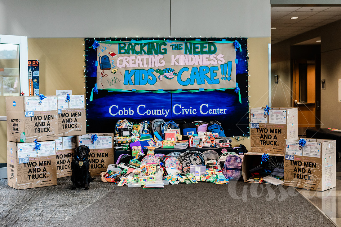 Large display of collected school supplies to be donated in the lobby of a community center.
