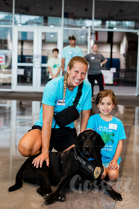 Rose the comfort dog, with cobb county district attorney's office, poses with child and mother. 