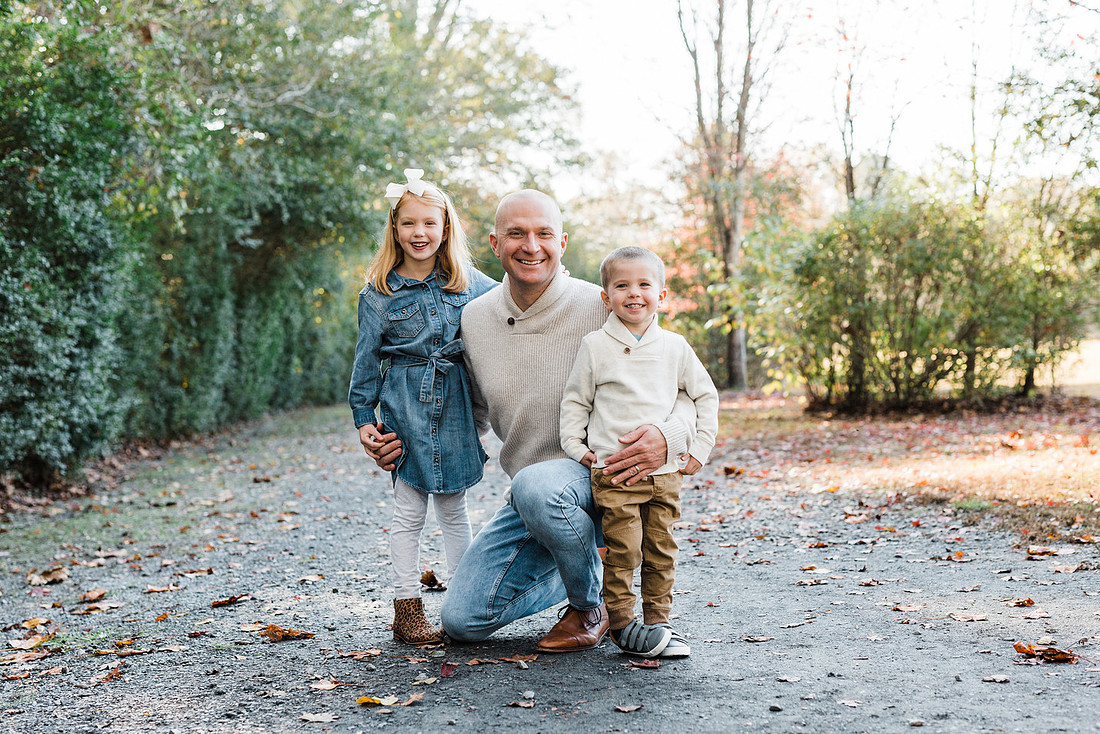 Family poses and enjoys candid moments during a mini session in a park