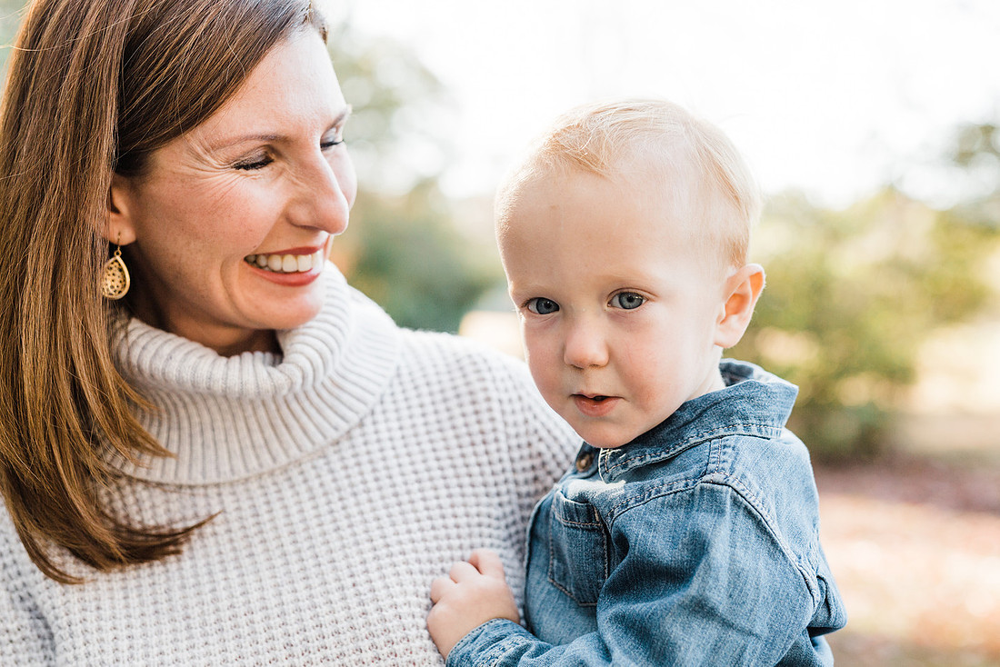Family poses and enjoys candid moments during a mini session in a park
