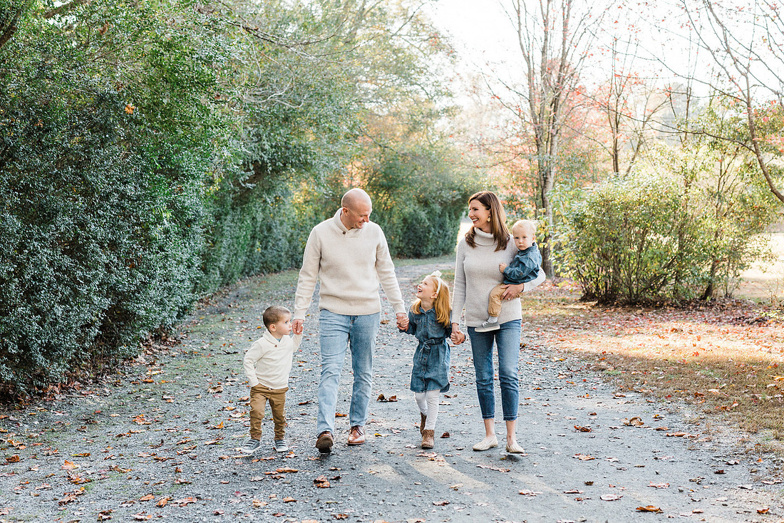 Family poses and enjoys candid moments during a mini session in a park