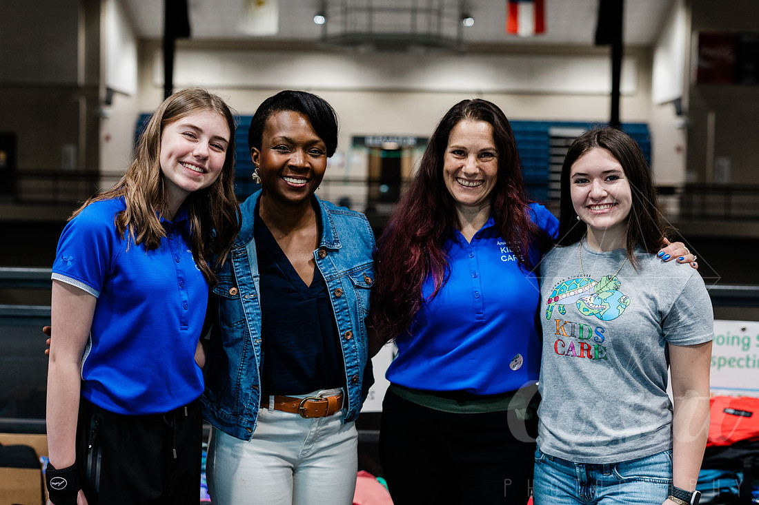 Cobb County Chairwoman Lisa Cupid stands together with Jaida Burke, founder of KIDS CARE, and her mother and friend, while at the School Supply Drive. 