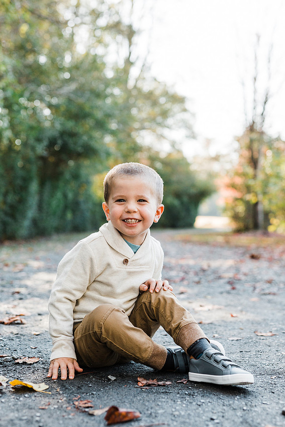 Family poses and enjoys candid moments during a mini session in a park