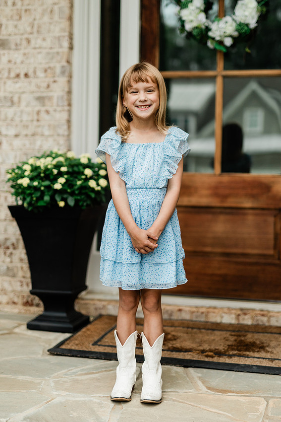 girl smiles on her porch for the first day of school in cobb county