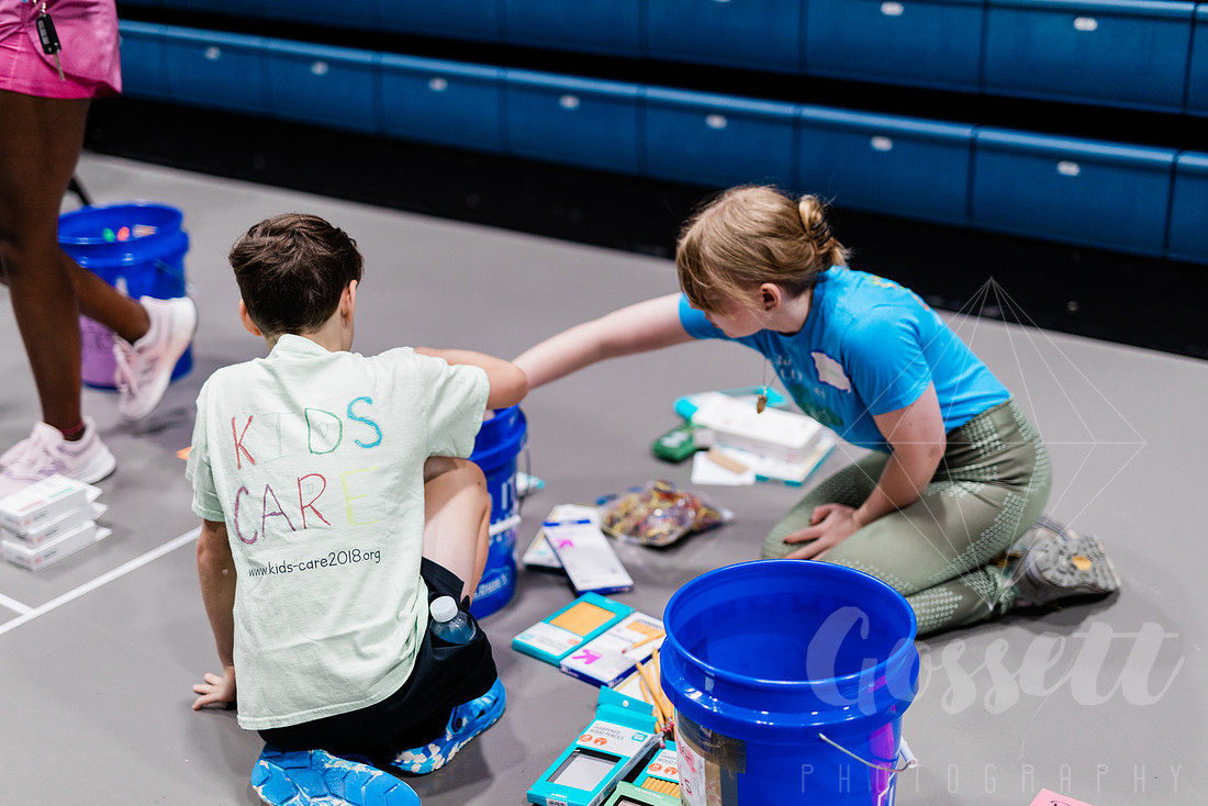 Children sort school supplies to be donated.