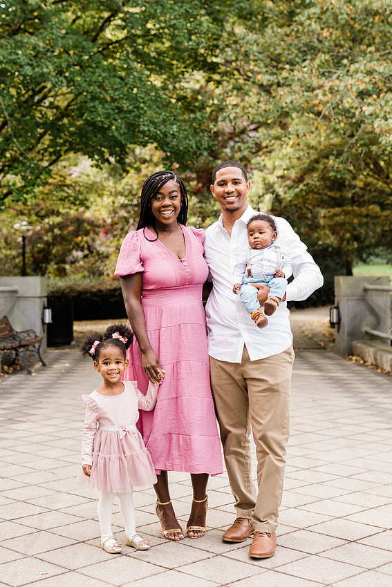 A family holding hands in a mini session at outdoor atlanta park.