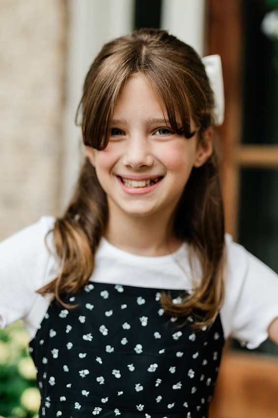 Girl smiles for the camera on her front porch the day before school starts. 