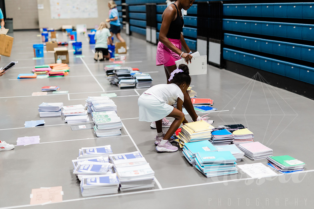 Child sorts school supplies to be donated